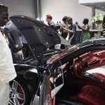 A man looks at a Porsche in Lagos