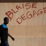 A man walks by graffiti reading “Blaise get out,” referring to Burkina Faso President Blaise Compaore, in Ouagadougou